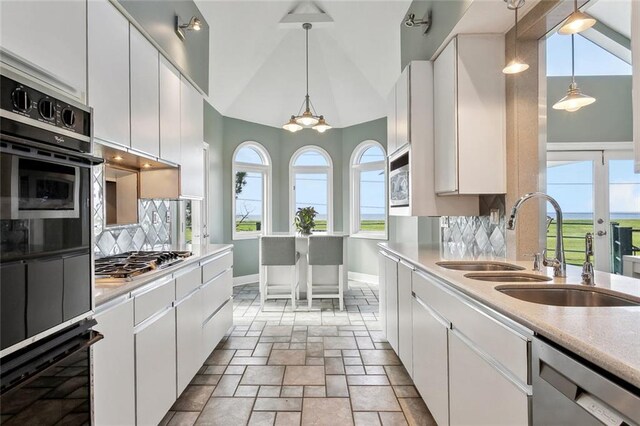 68 Verde St, Kenner, LA 70065 - kitchen with appliances with stainless steel finishes, baseboards, tasteful backsplash, light countertops, and white cabinets