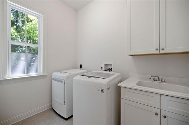 1029 Spring Haven Ln, Madisonville, LA 70447 - washroom featuring cabinet space, washer and dryer, light tile patterned floors, and baseboards