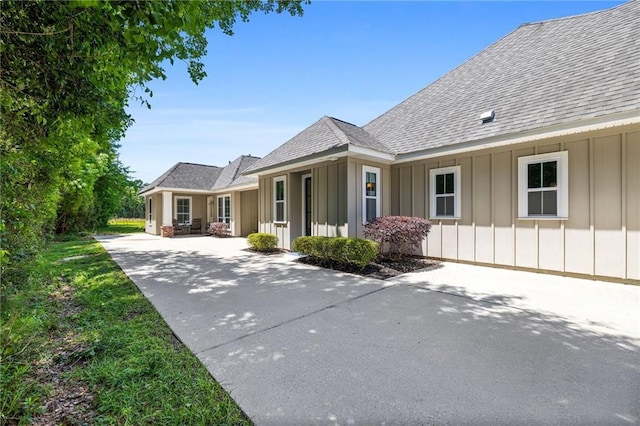 1029 Spring Haven Ln, Madisonville, LA 70447 - view of home's exterior with board and batten siding, driveway, and roof with shingles