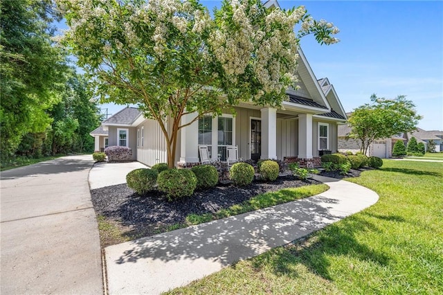 1029 Spring Haven Ln, Madisonville, LA 70447 - view of front of house with a porch, a front yard, board and batten siding, a standing seam roof, and metal roof