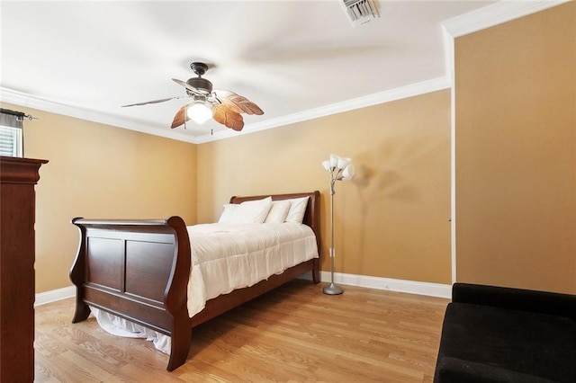bedroom featuring light wood finished floors, baseboards, crown molding, and a ceiling fan
