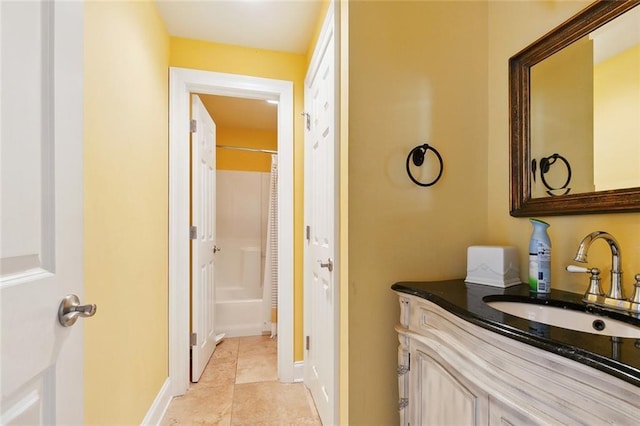 bathroom featuring vanity, baseboards, a shower, and tile patterned floors