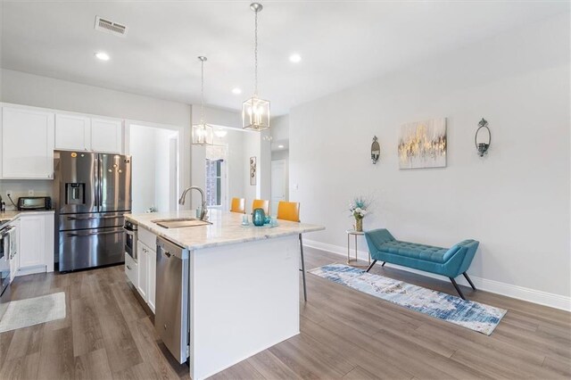 3225 Delaware Ave, Kenner, LA 70065 - kitchen featuring stainless steel appliances, a sink, wood finished floors, white cabinets, and recessed lighting