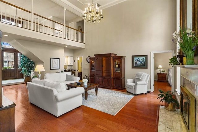 137 Lakewood Estates Dr, New Orleans, LA 70131 - living room featuring a high ceiling, a fireplace, wood finished floors, a chandelier, and baseboards