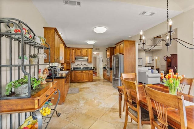 137 Lakewood Estates Dr, New Orleans, LA 70131 - kitchen with appliances with stainless steel finishes, dark countertops, brown cabinetry, a sink, and under cabinet range hood