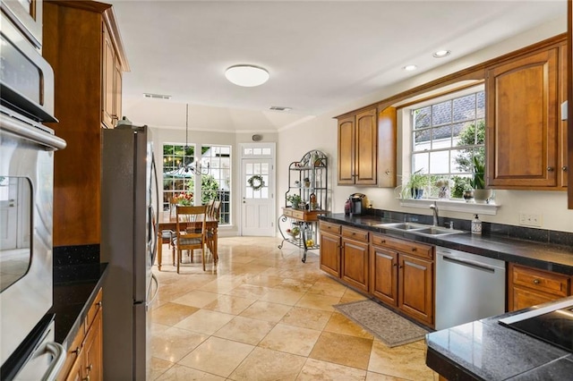137 Lakewood Estates Dr, New Orleans, LA 70131 - kitchen featuring appliances with stainless steel finishes, brown cabinets, dark countertops, recessed lighting, and a sink