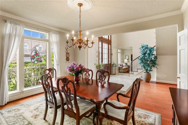 137 Lakewood Estates Dr, New Orleans, LA 70131 - dining room featuring crown molding, a chandelier, light wood-type flooring, a textured ceiling, and stairway