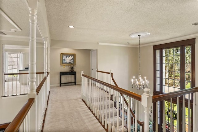 137 Lakewood Estates Dr, New Orleans, LA 70131 - corridor featuring an upstairs landing, a textured ceiling, light colored carpet, baseboards, and a chandelier