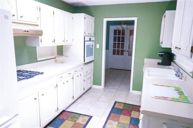 1513 Mason Smith Ave, Metairie, LA 70003 - kitchen with oven, a sink, under cabinet range hood, light countertops, and white cabinets
