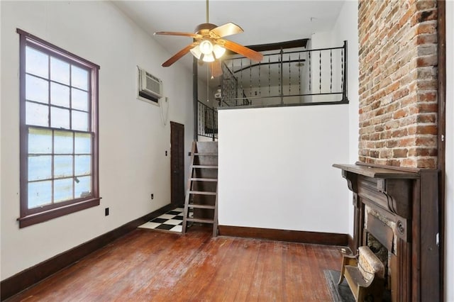 271214 Burgundy St, New Orleans, LA 70117 - unfurnished living room featuring a fireplace, ceiling fan, hardwood / wood-style flooring, stairs, and an AC wall unit