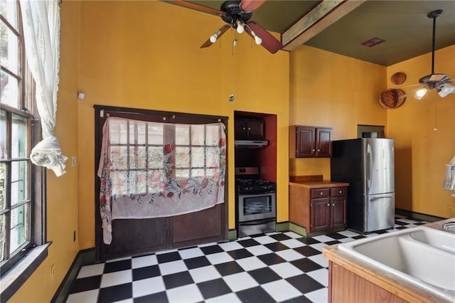 271214 Burgundy St, New Orleans, LA 70117 - kitchen featuring ceiling fan, tile patterned floors, appliances with stainless steel finishes, a towering ceiling, and under cabinet range hood