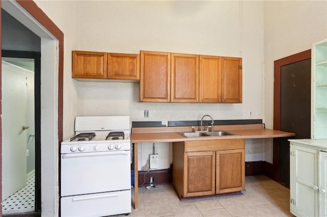 271214 Burgundy St, New Orleans, LA 70117 - kitchen with white gas stove, brown cabinets, and light tile patterned floors