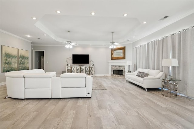 31057 Woodland Dr, Lacombe, LA 70445 - living room with light wood-type flooring, ceiling fan, recessed lighting, ornamental molding, and a tray ceiling