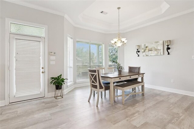 31057 Woodland Dr, Lacombe, LA 70445 - dining room with a chandelier, crown molding, light wood-type flooring, a tray ceiling, and baseboards