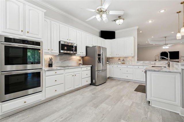 31057 Woodland Dr, Lacombe, LA 70445 - kitchen featuring appliances with stainless steel finishes, ceiling fan, a sink, crown molding, and a peninsula
