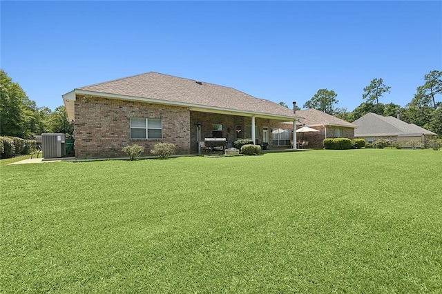 31057 Woodland Dr, Lacombe, LA 70445 - rear view of property featuring a yard, brick siding, and central air condition unit