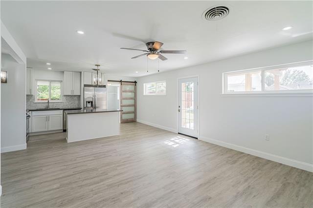 9004 Camille Ct, River Ridge, LA 70123 - unfurnished living room with a barn door, baseboards, light wood-style floors, recessed lighting, and a ceiling fan