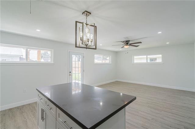 9004 Camille Ct, River Ridge, LA 70123 - kitchen with light wood-style floors, baseboards, dark countertops, recessed lighting, and a chandelier