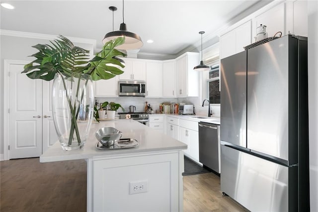 1641 Continental Dr, Covington, LA 70433 - kitchen featuring appliances with stainless steel finishes, ornamental molding, a sink, white cabinets, and light countertops