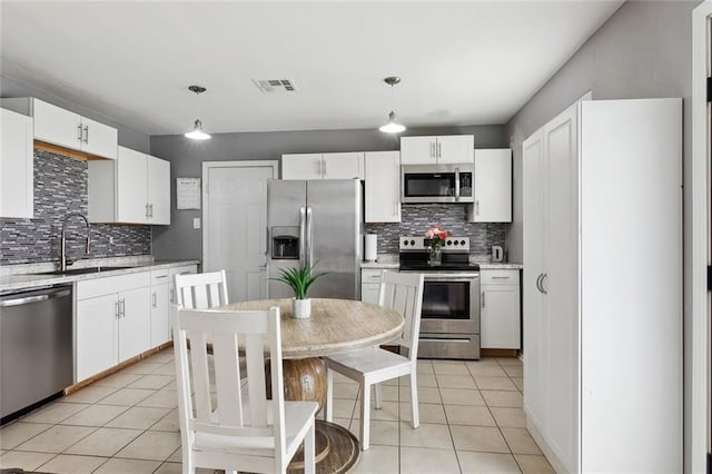 2525 Joy Ann Dr, Marrero, LA 70072 - kitchen featuring stainless steel appliances, light tile patterned floors, tasteful backsplash, and hanging light fixtures