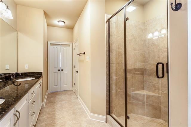 217 Coushatta Cir, Madisonville, LA 70447 - full bathroom featuring a stall shower, double vanity, and baseboards