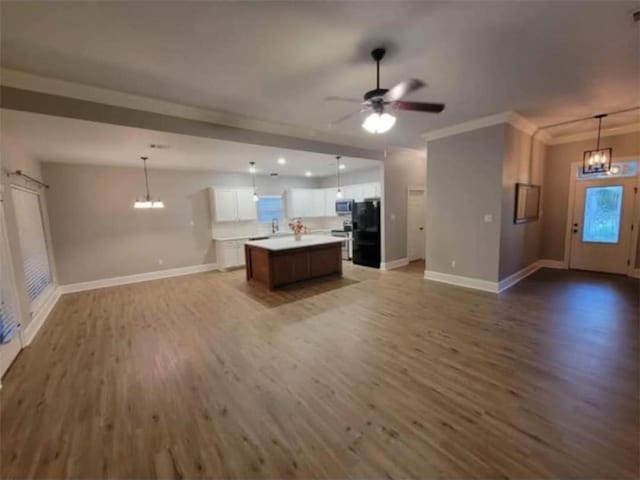 40153 Maison Lafitte Blvd, Ponchatoula, LA 70454 - unfurnished living room featuring wood finished floors, a chandelier, ceiling fan, and ornamental molding