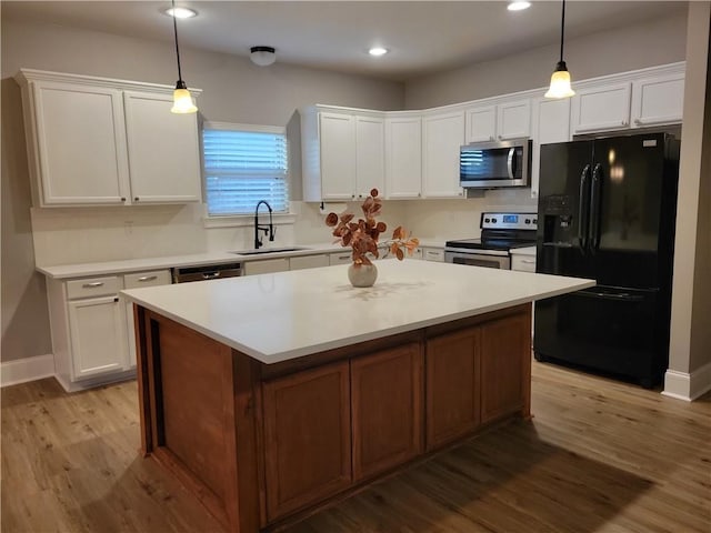40153 Maison Lafitte Blvd, Ponchatoula, LA 70454 - kitchen with stainless steel appliances, white cabinetry, light wood-style flooring, a center island, and light countertops