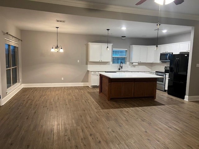 40153 Maison Lafitte Blvd, Ponchatoula, LA 70454 - kitchen featuring stainless steel appliances, dark wood-style flooring, a center island, ornamental molding, and light countertops