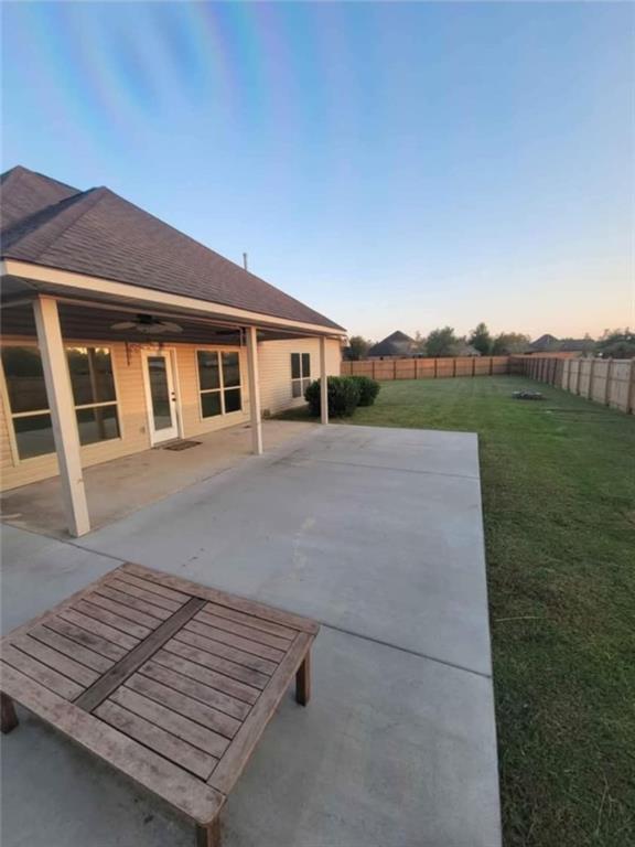 40153 Maison Lafitte Blvd, Ponchatoula, LA 70454 - patio terrace at dusk featuring a fenced backyard and a patio area