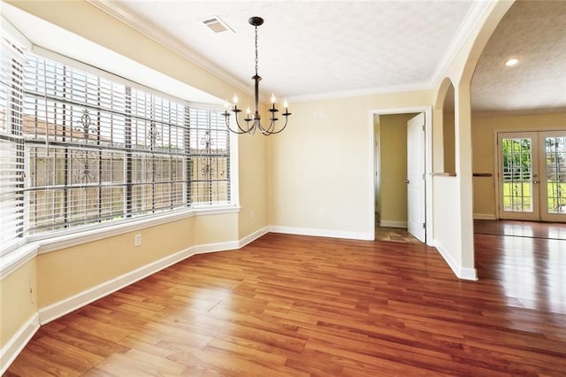 5736 E Louis Prima Dr, New Orleans, LA 70128 - unfurnished dining area with arched walkways, crown molding, wood finished floors, a chandelier, and baseboards