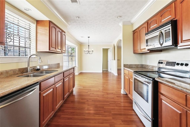 5736 E Louis Prima Dr, New Orleans, LA 70128 - kitchen with stainless steel appliances, a sink, a chandelier, dark wood-style floors, and ornamental molding