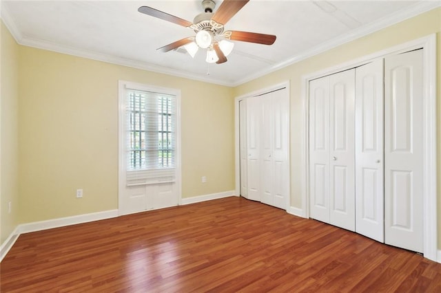 5736 E Louis Prima Dr, New Orleans, LA 70128 - unfurnished bedroom with wood finished floors, multiple closets, crown molding, baseboards, and ceiling fan