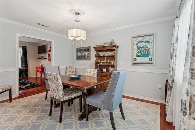 1417 Washington Ct, Slidell, LA 70458 - dining area featuring wood finished floors, ornamental molding, and a chandelier