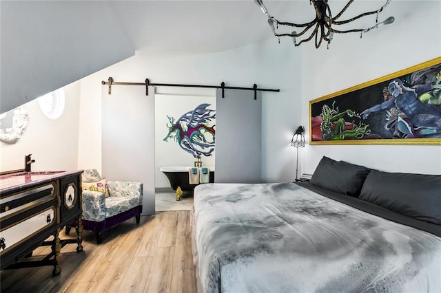 111214 Touro St, New Orleans, LA 70116 - bedroom featuring a barn door and wood finished floors