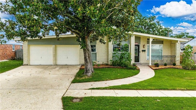 4401 Apollo Dr, Metairie, LA 70003 - view of front of house with a front yard, brick siding, a garage, driveway, and a porch