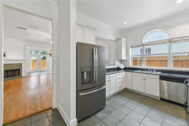 506 Papworth Ave, Metairie, LA 70005 - kitchen with stainless steel appliances, a sink, white cabinetry, ornamental molding, and light tile patterned floors