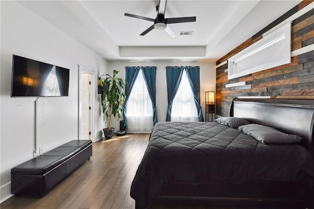 2728 Bienville St, New Orleans, LA 70119 - bedroom featuring wood finished floors, a tray ceiling, and a ceiling fan