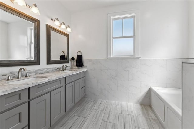 2728 Bienville St, New Orleans, LA 70119 - full bath featuring tile walls, wainscoting, double vanity, and a tub to relax in