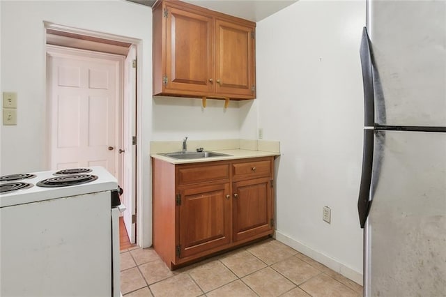 519 Madison St Unit C, New Orleans, LA 70116 - kitchen featuring white range with electric cooktop, light countertops, light tile patterned floors, and brown cabinets
