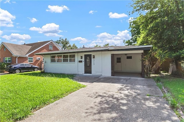 513 Roseland Pkwy, Harahan, LA 70123 - view of front of home featuring a front lawn, concrete driveway, an attached carport, and brick siding