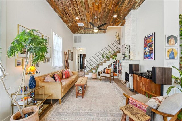 2712 Saint Thomas St, New Orleans, LA 70130 - living room with wood ceiling, stairway, ceiling fan, wood finished floors, and a high ceiling
