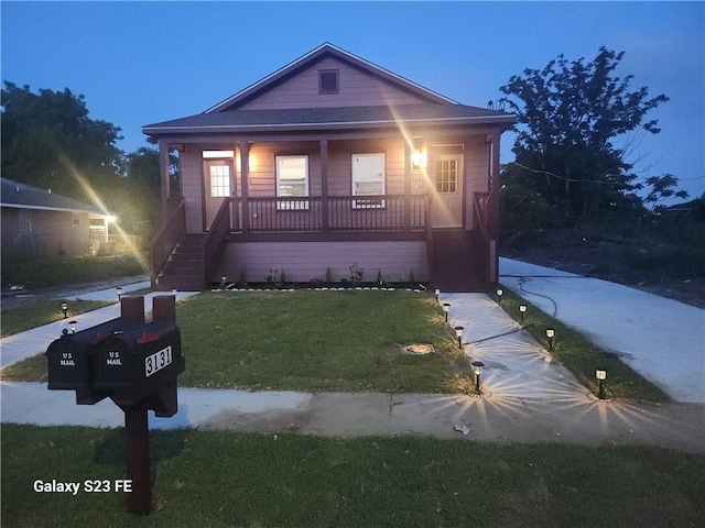 313331 Clouet St, New Orleans, LA 70126 - bungalow featuring covered porch, stairway, and a front yard