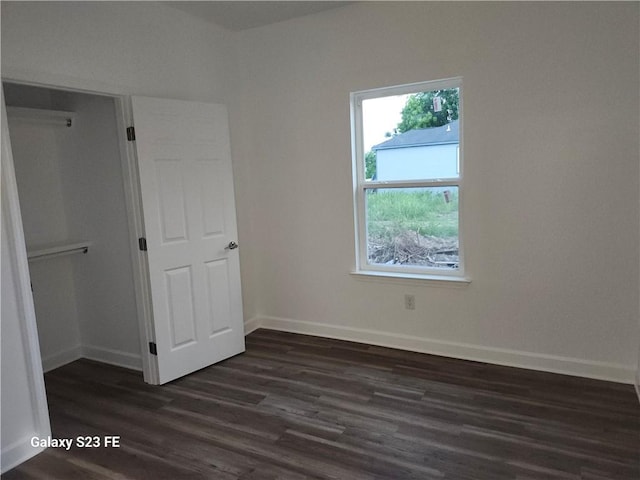 313331 Clouet St, New Orleans, LA 70126 - unfurnished bedroom with dark wood-style flooring, baseboards, and a closet