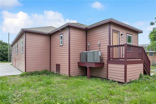 313331 Clouet St, New Orleans, LA 70126 - back of property with central AC unit, a lawn, a wooden deck, and stairs