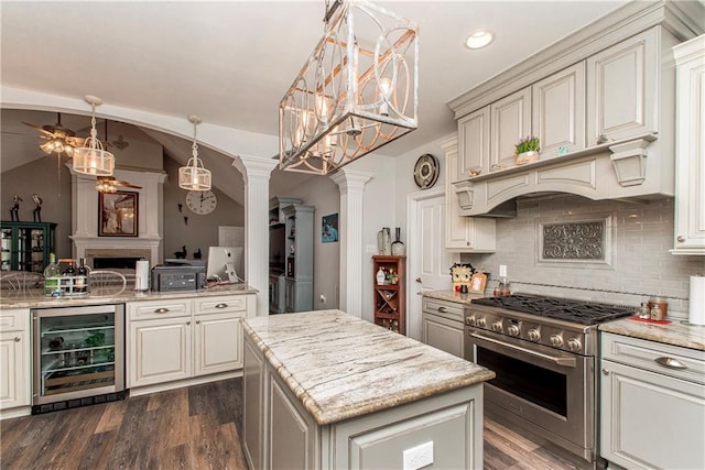 kitchen featuring stainless steel range, beverage cooler, ornate columns, tasteful backsplash, and dark wood finished floors