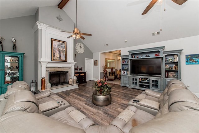 living area featuring a ceiling fan, wood finished floors, beam ceiling, a fireplace, and high vaulted ceiling