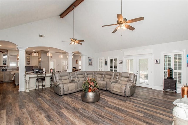 living room with ornate columns, a ceiling fan, arched walkways, high vaulted ceiling, and dark wood-type flooring
