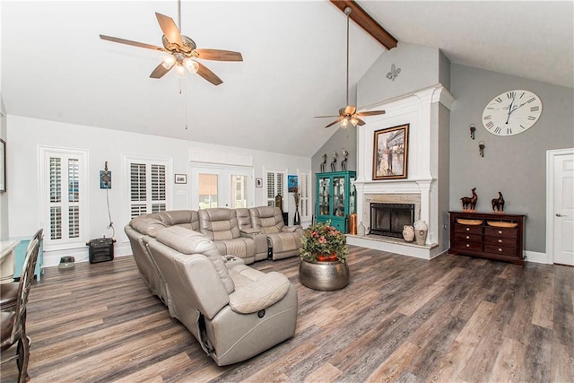 living room featuring a ceiling fan, wood finished floors, high vaulted ceiling, beamed ceiling, and a fireplace with raised hearth