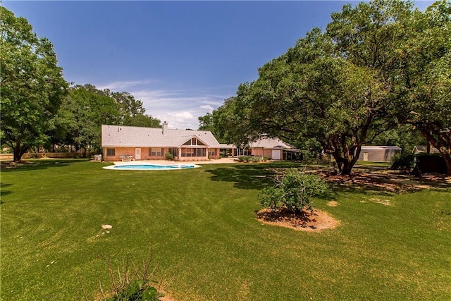view of green lawn featuring an outdoor pool