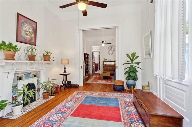 2329 Dauphine St, New Orleans, LA 70117 - living area featuring a ceiling fan, wood finished floors, a fireplace, and baseboards